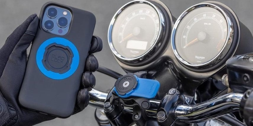 Rider putting his phone with Quad-lock mag case onto motorcycle Quad-lock fork stem mount.