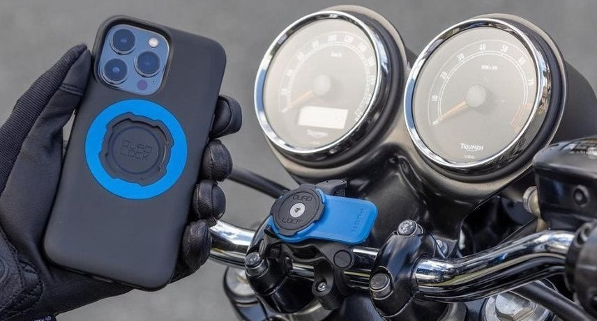 Rider putting his phone with Quad-lock mag case onto motorcycle Quad-lock fork stem mount. 