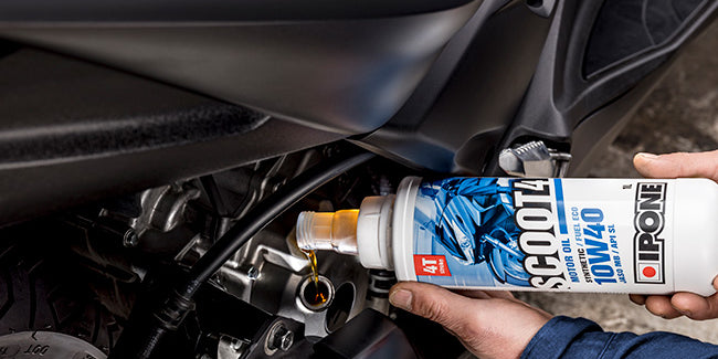 Man pouring Scoot 4 10w40 Semi Synthetic oil into the motorcycle engine.